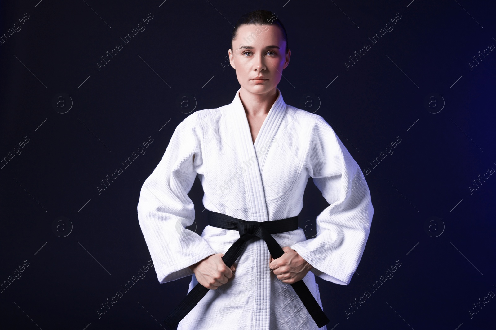 Photo of Karate fighter in kimono on dark background