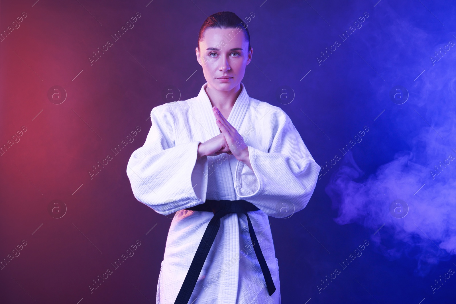 Photo of Karate fighter in kimono on color background