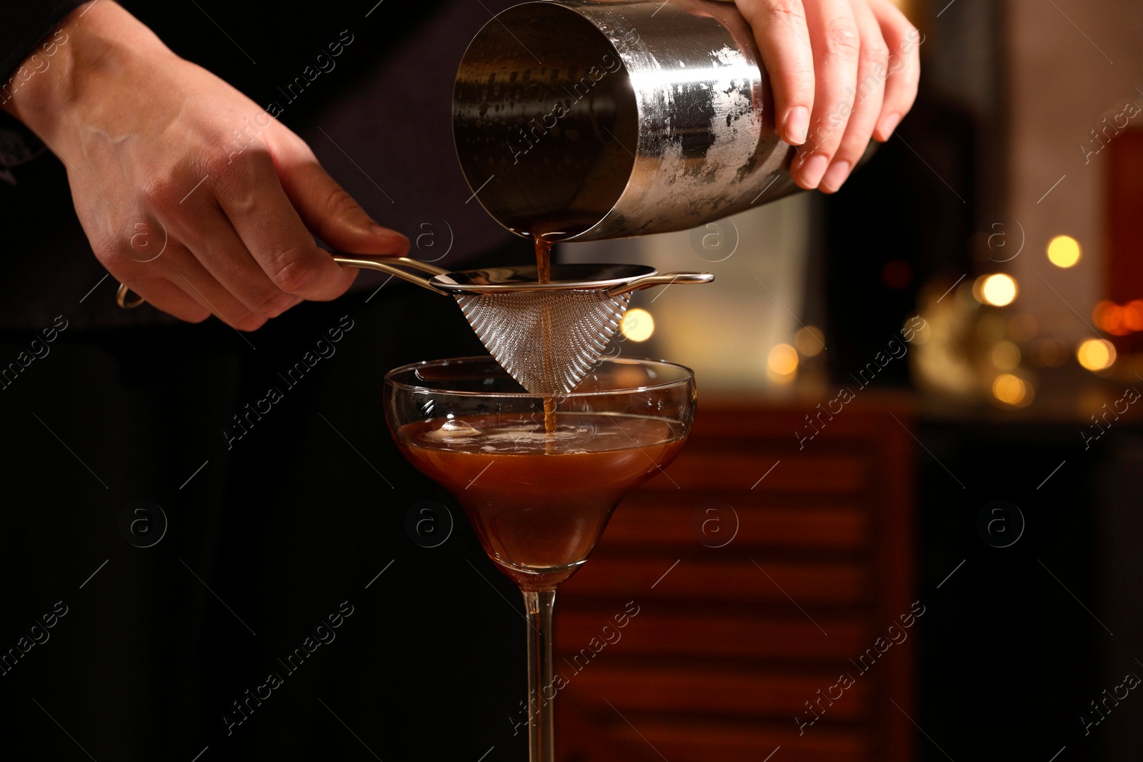 Photo of Bartender making delicious espresso martini in bar, closeup