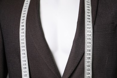 Photo of Male mannequin with brown jacket and measuring tape, closeup