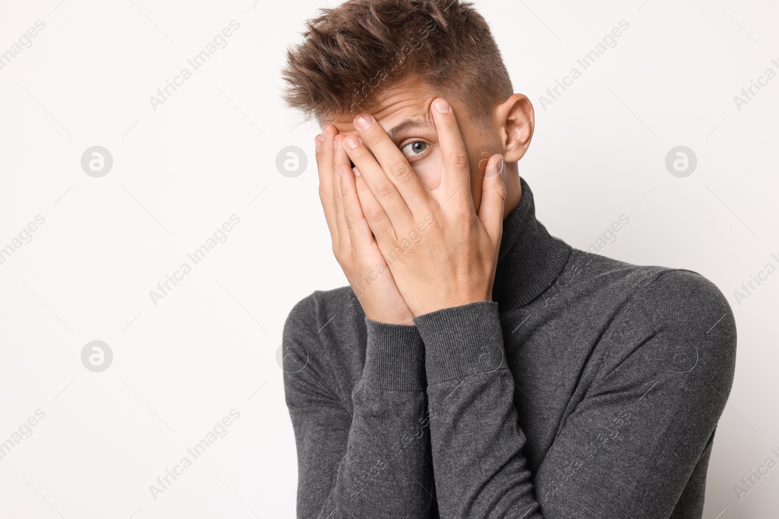 Photo of Portrait of scared young man on light background, space for text