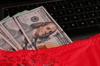 Photo of Sex work. Underwear and money on laptop, closeup