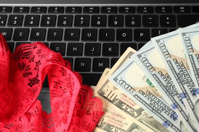 Photo of Sex work. Money and panties on laptop, closeup