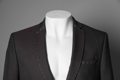 Photo of Semi-ready jacket on mannequin against grey background, closeup