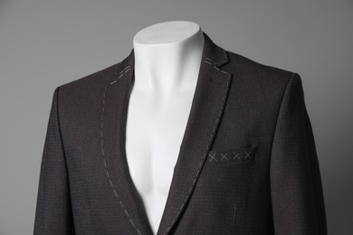 Photo of Semi-ready jacket on mannequin against grey background, closeup