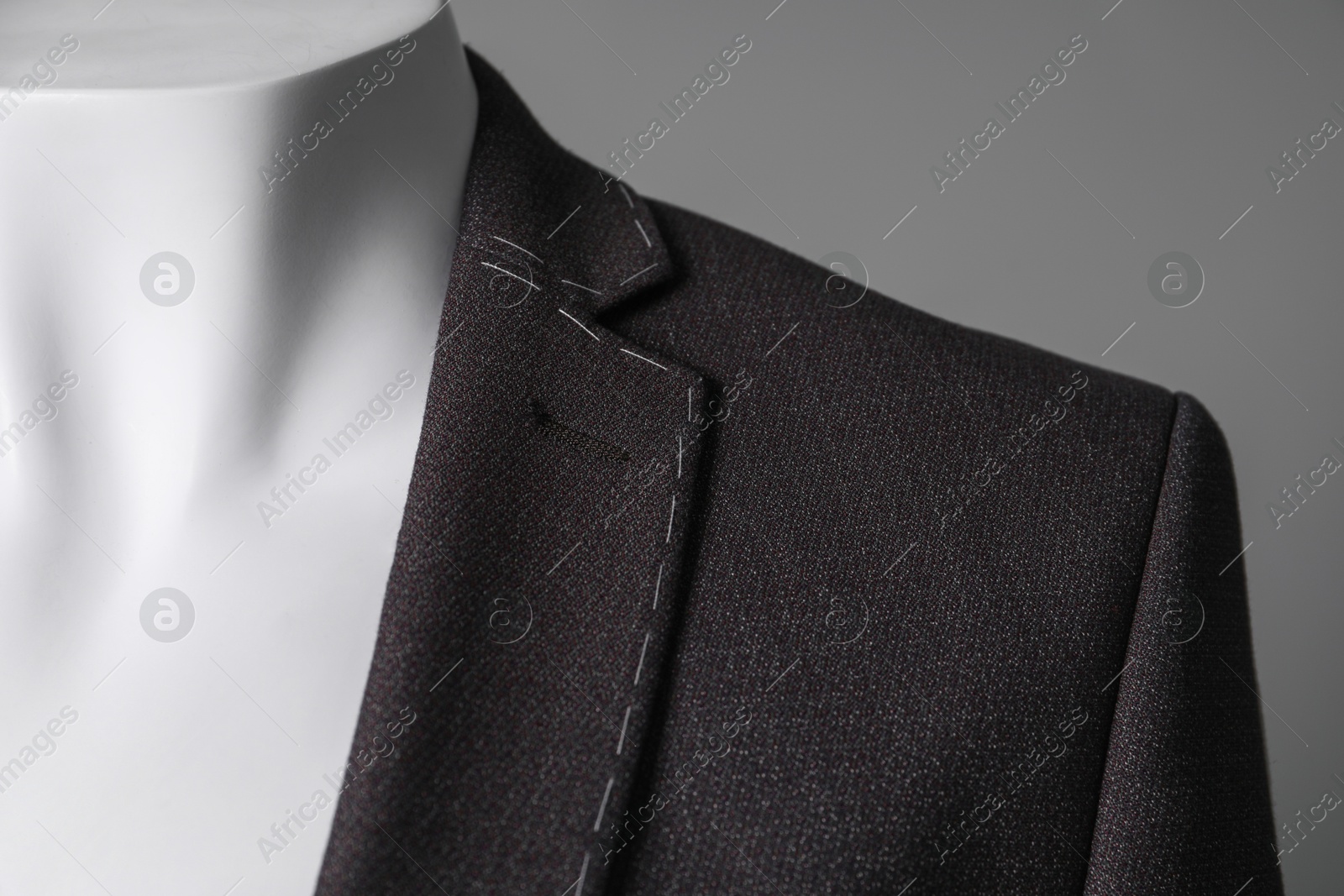 Photo of Semi-ready jacket on mannequin against grey background, closeup