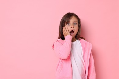 Photo of Scared little girl on pink background. Space for text