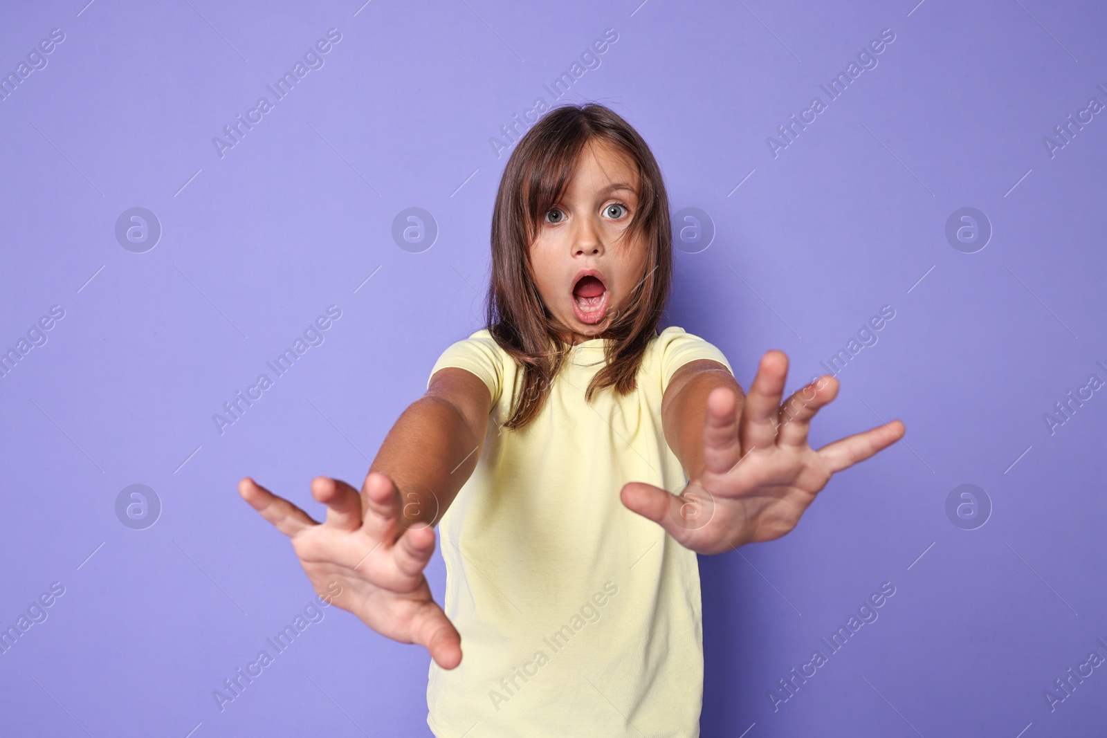 Photo of Portrait of scared little girl on violet background