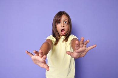 Photo of Portrait of scared little girl on violet background