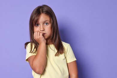 Photo of Portrait of scared little girl on violet background. Space for text