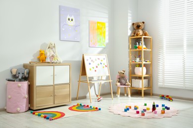 Photo of Beautiful child's room interior with toys and stylish furniture