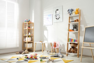 Photo of Beautiful child's room interior with toys and stylish furniture