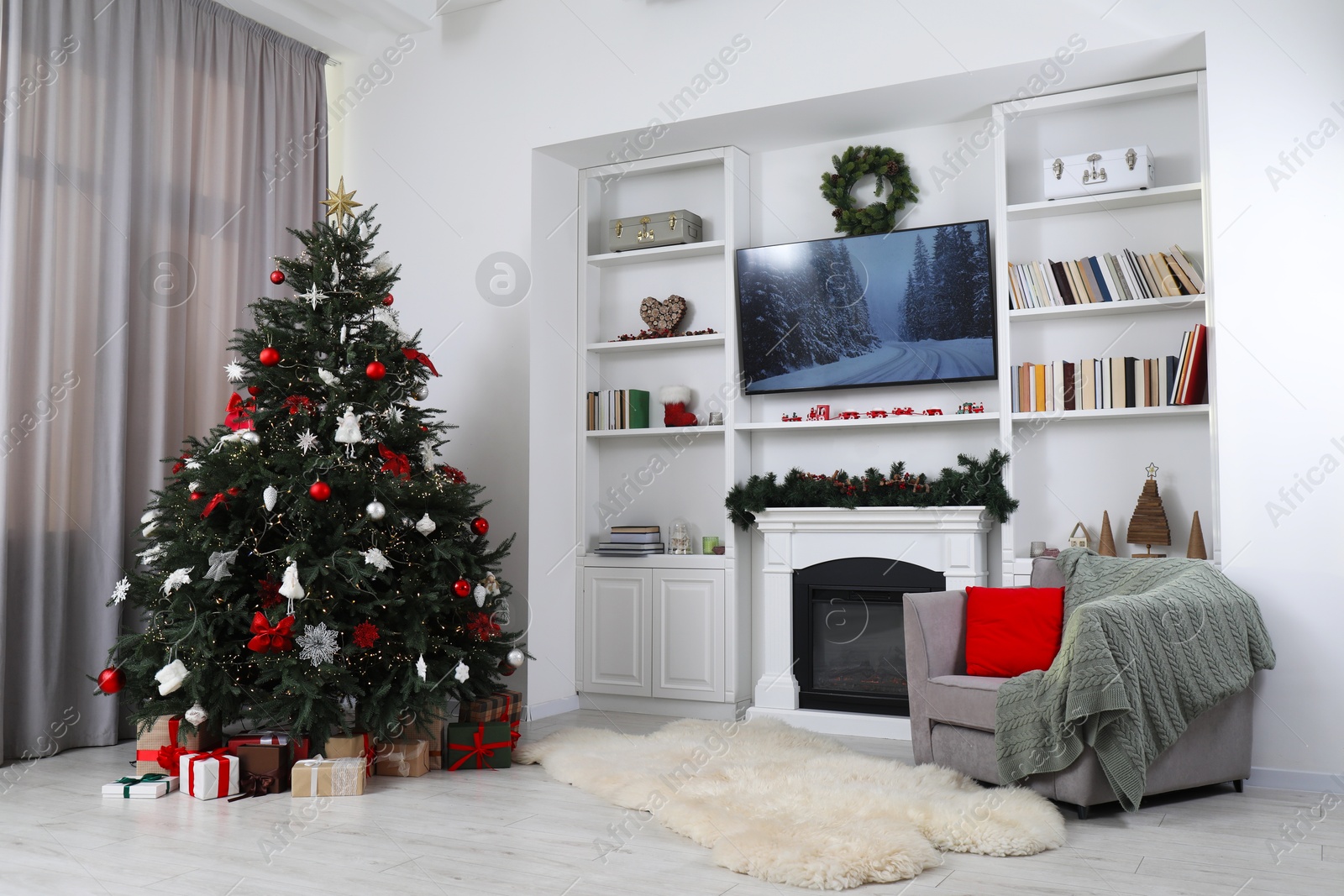 Photo of Beautifully decorated Christmas tree near fireplace in room. Festive interior design