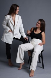 Photo of Portrait of beautiful twin sisters on grey background