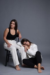 Photo of Portrait of beautiful twin sisters on grey background