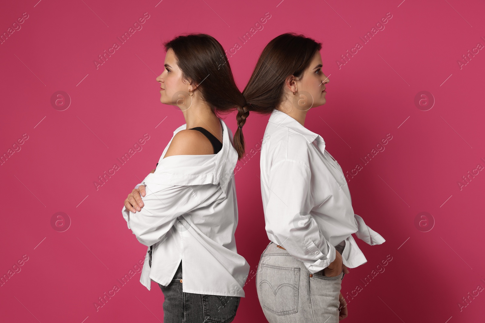 Photo of Portrait of beautiful twin sisters on pink background