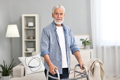 Photo of Senior man using walking frame at home