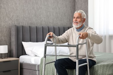 Photo of Senior man with walking frame on bed at home