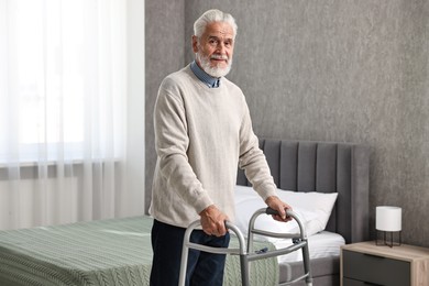 Photo of Senior man using walking frame at home