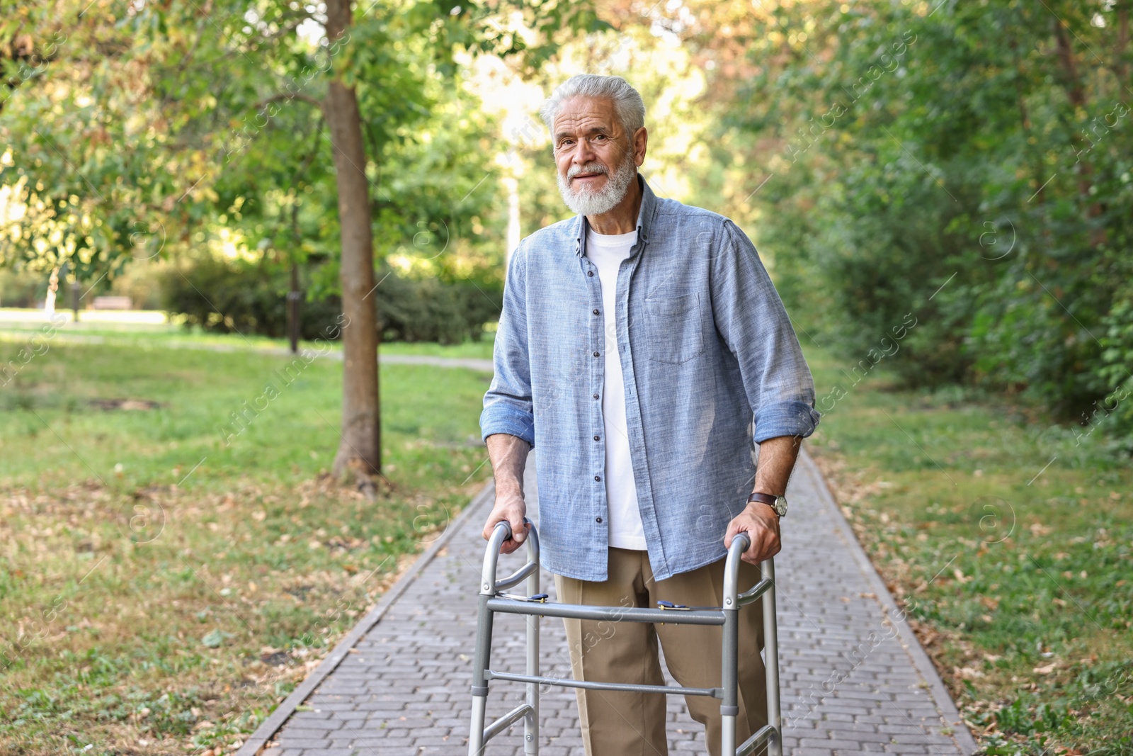 Photo of Senior man with walking frame in park