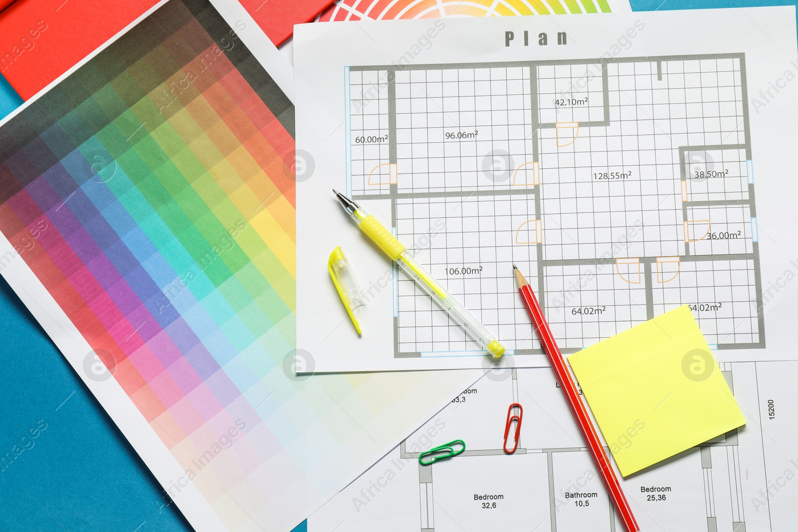 Photo of Designer's workplace with house plans, color palettes and stationery on blue table, flat lay