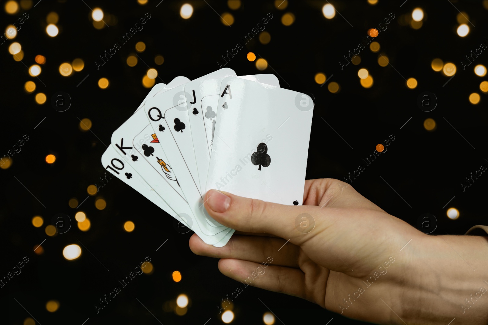 Photo of Poker game. Woman with playing cards against dark background, closeup