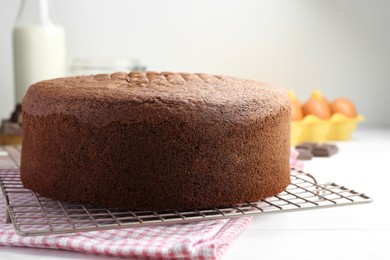 Photo of Tasty chocolate sponge cake on white wooden table, closeup