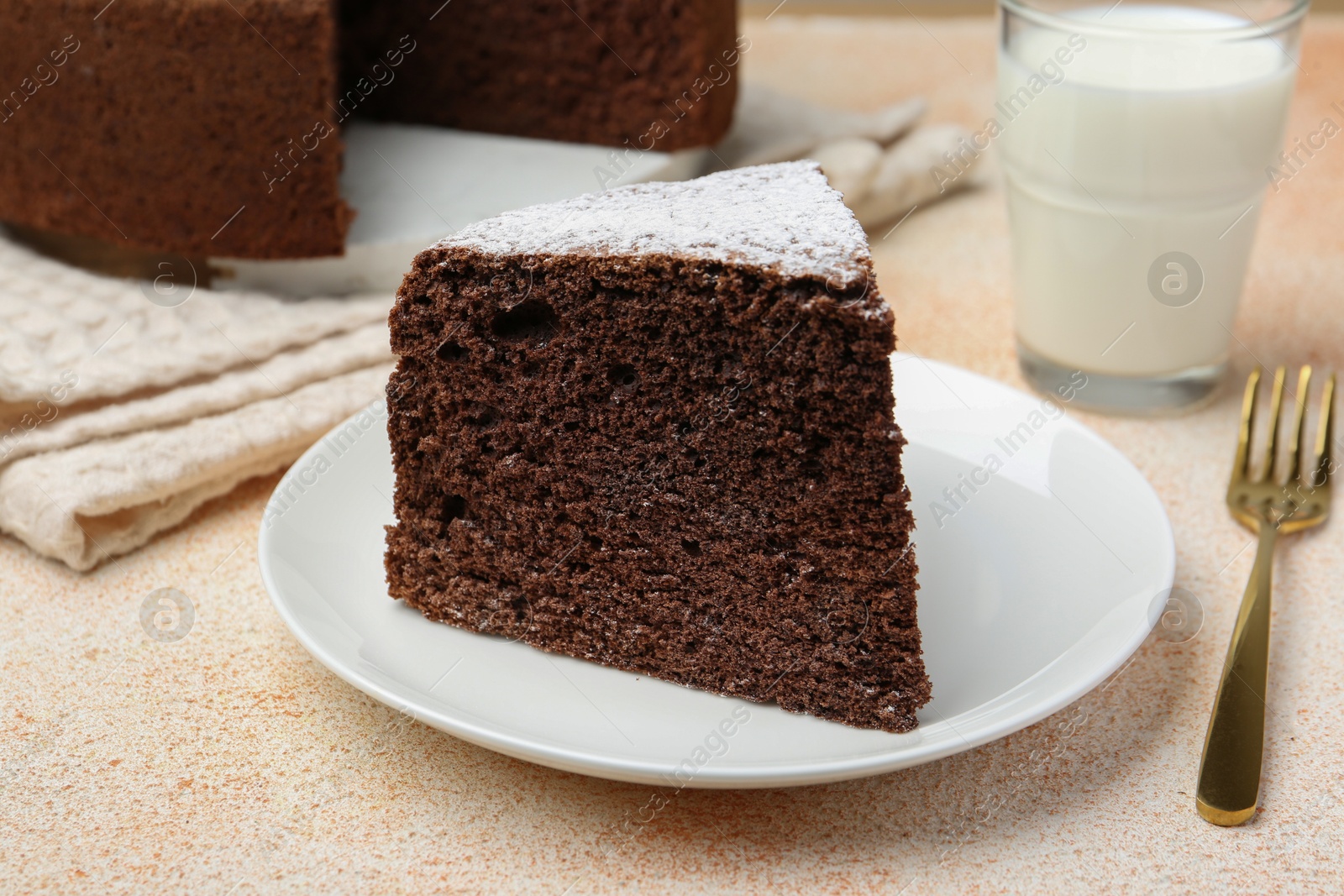 Photo of Piece of tasty chocolate sponge cake served on light table, closeup