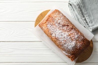 Photo of Tasty sponge cake with powdered sugar on white wooden table, top view. Space for text