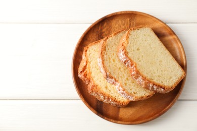 Photo of Freshly baked sponge cake on white wooden table, top view. Space for text