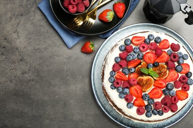 Delicious chocolate sponge cake with berries served on grey table, top view. Space for text