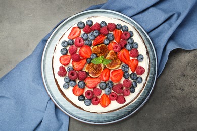 Delicious chocolate sponge cake with berries on grey table, top view