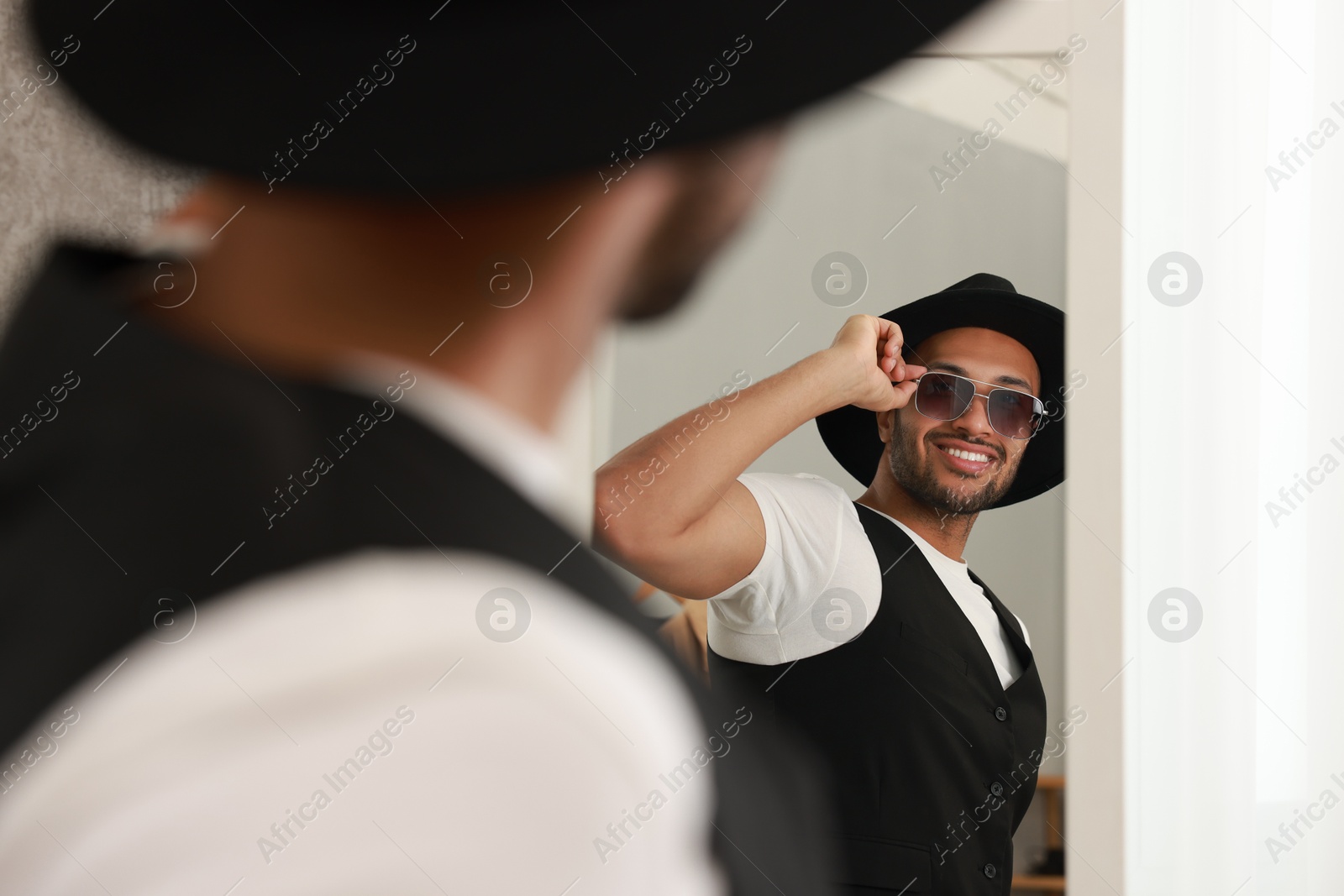 Photo of Smiling man looking at mirror at home