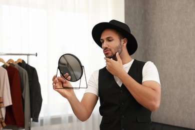 Photo of Handsome man looking at mirror at home