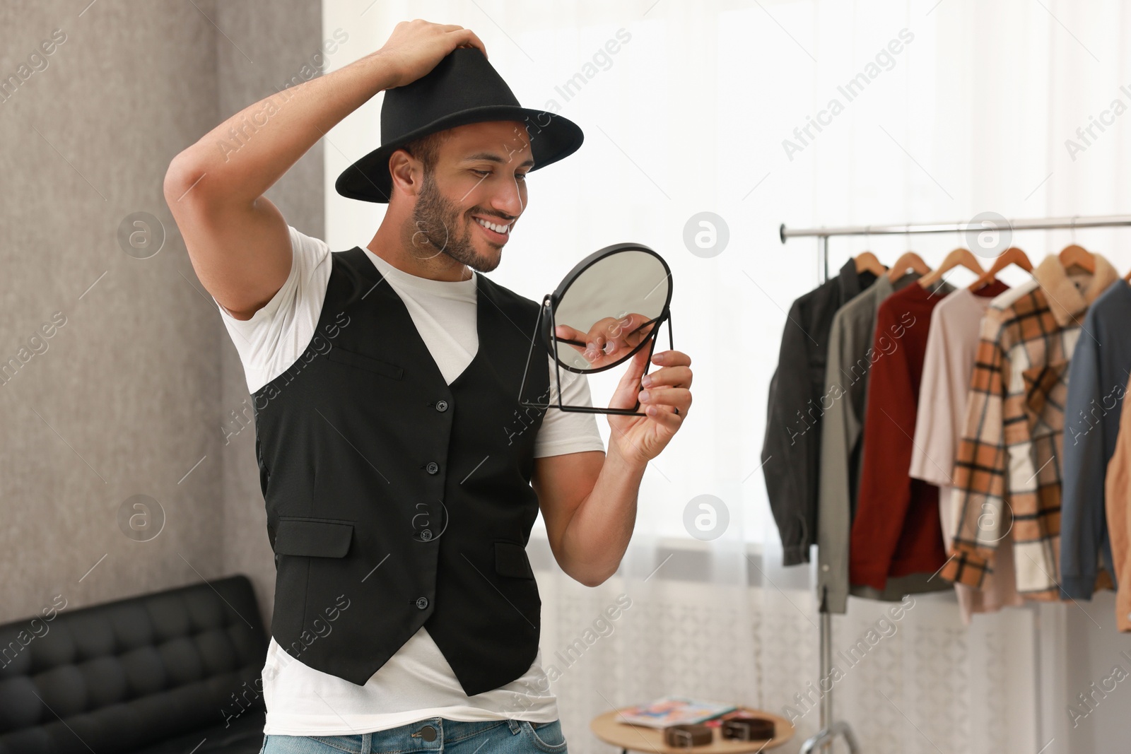 Photo of Smiling man looking at mirror at home