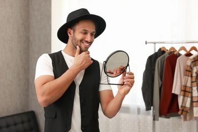 Photo of Smiling man looking at mirror at home