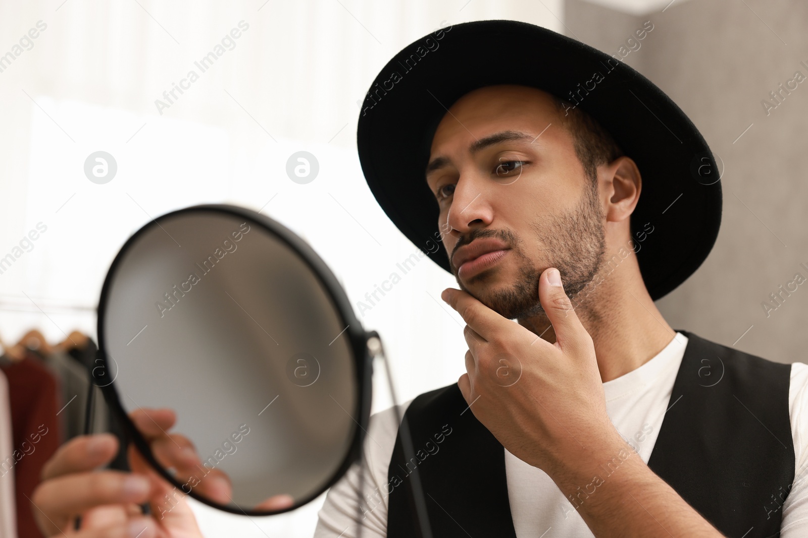 Photo of Handsome man looking at mirror at home