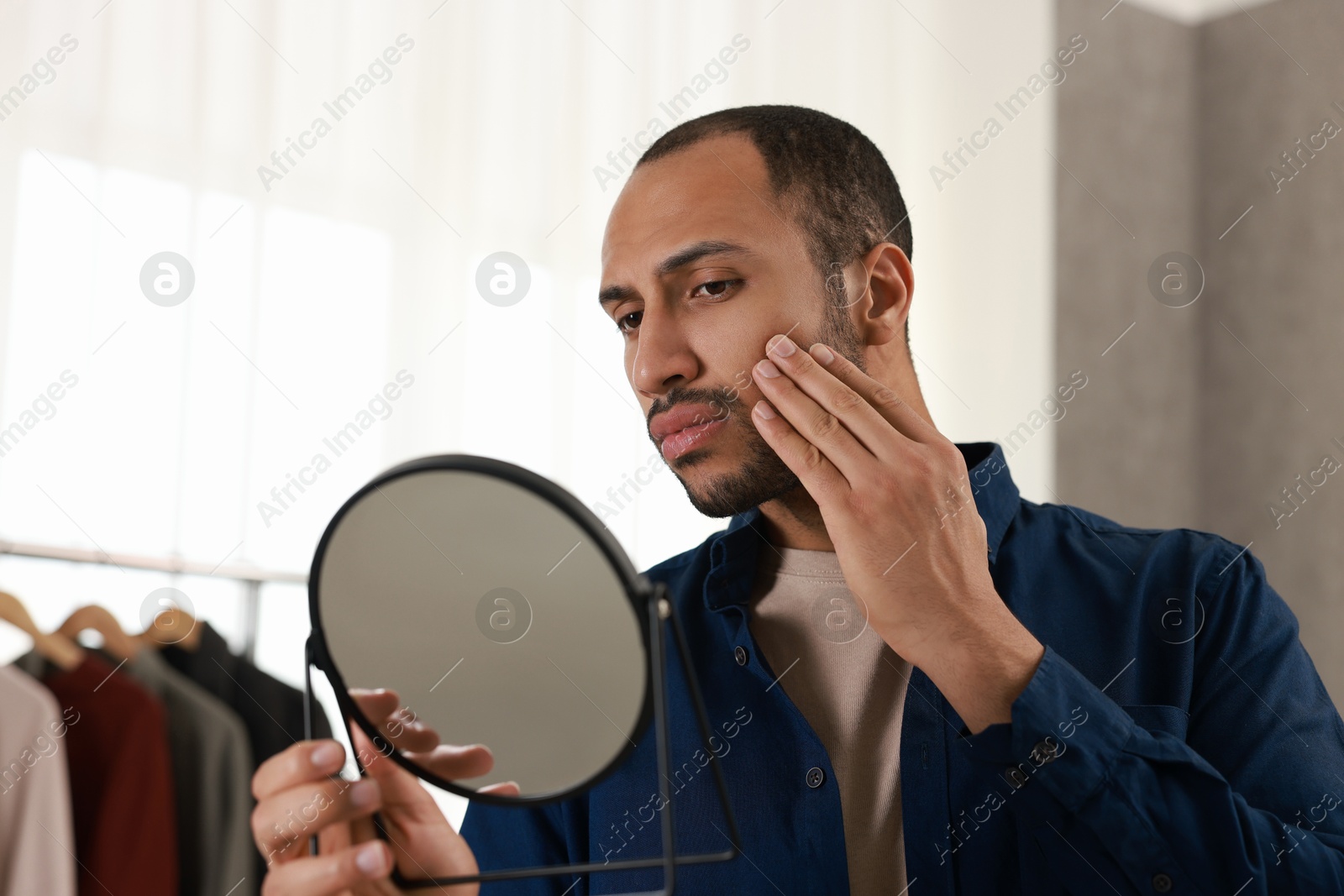 Photo of Handsome man looking at mirror at home