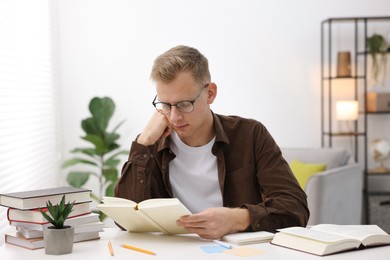 Photo of Student preparing for exam at table indoors