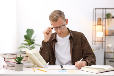 Photo of Student preparing for exam at table indoors