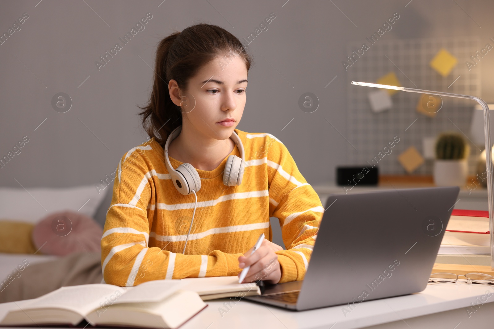 Photo of Student preparing for exam with laptop at table indoors