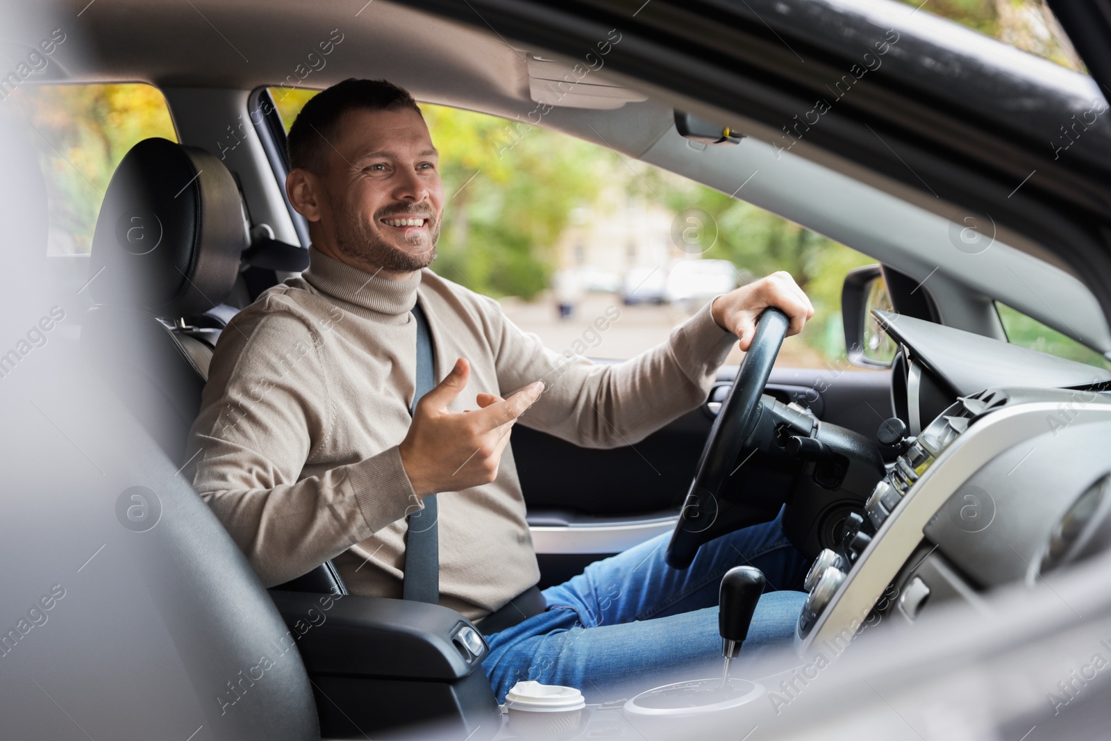 Photo of Man driving modern car, view through window