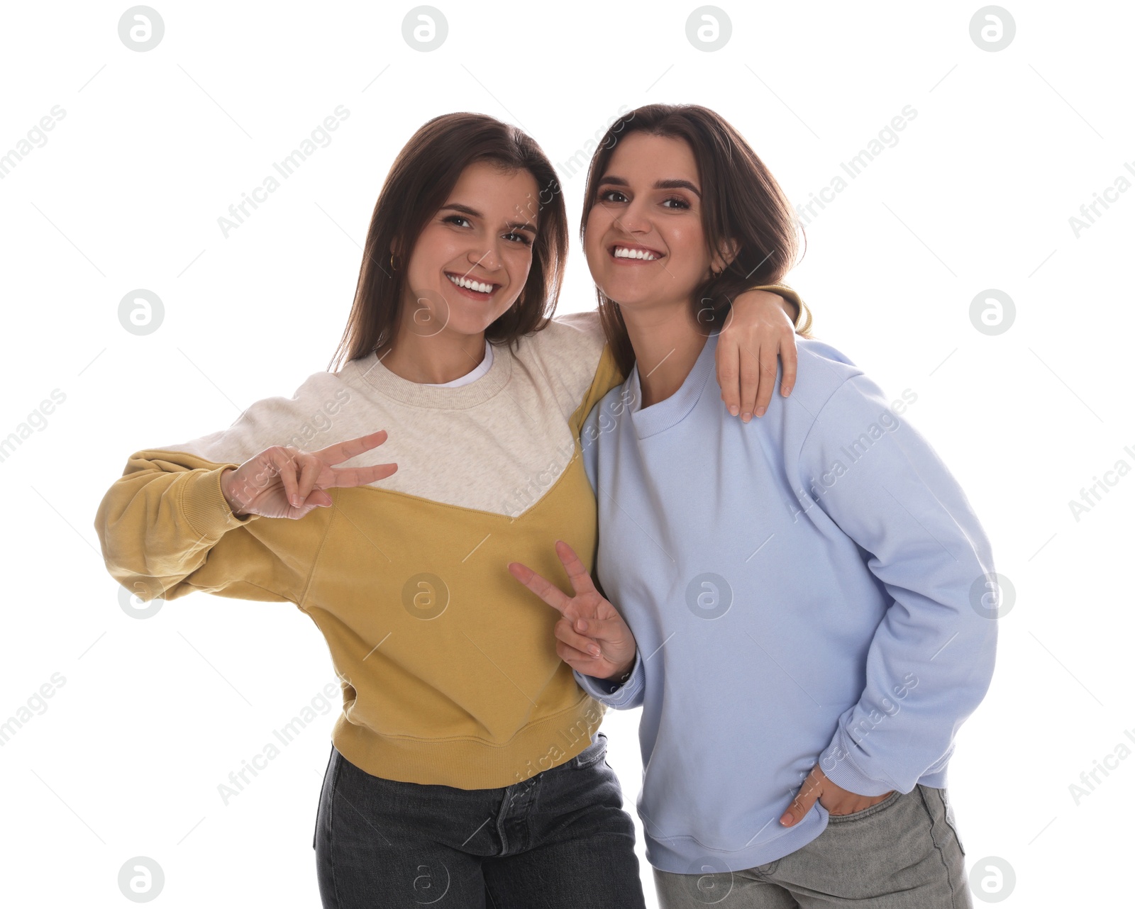 Photo of Portrait of beautiful twin sisters on white background