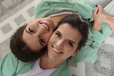 Photo of Portrait of beautiful twin sisters at home, top view