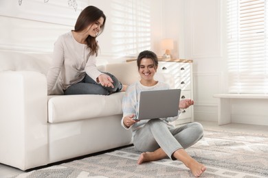 Photo of Beautiful twin sisters with laptop at home