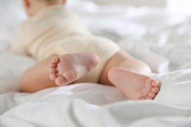 Photo of Cute little baby on bed indoors, closeup