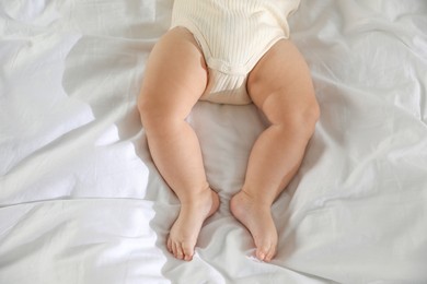 Photo of Cute little baby on bed indoors, top view