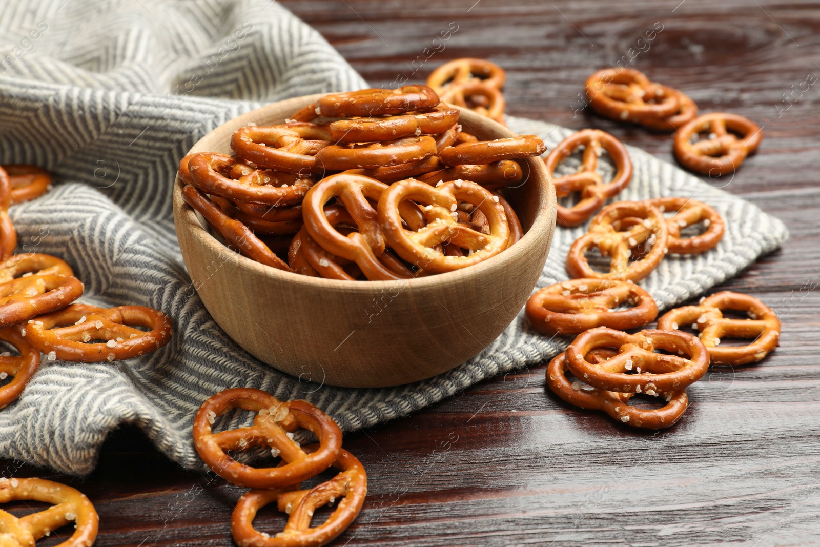 Photo of Tasty pretzel crackers on wooden table, closeup