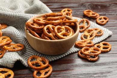 Photo of Tasty pretzel crackers on wooden table, closeup