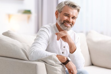 Photo of Portrait of happy middle aged man on sofa at home